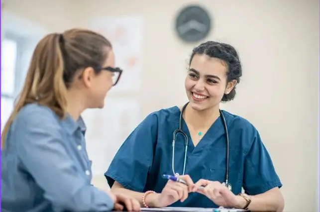Enfermera informando a paciente en consulta sanitaria sobre prueba diagnóstica
